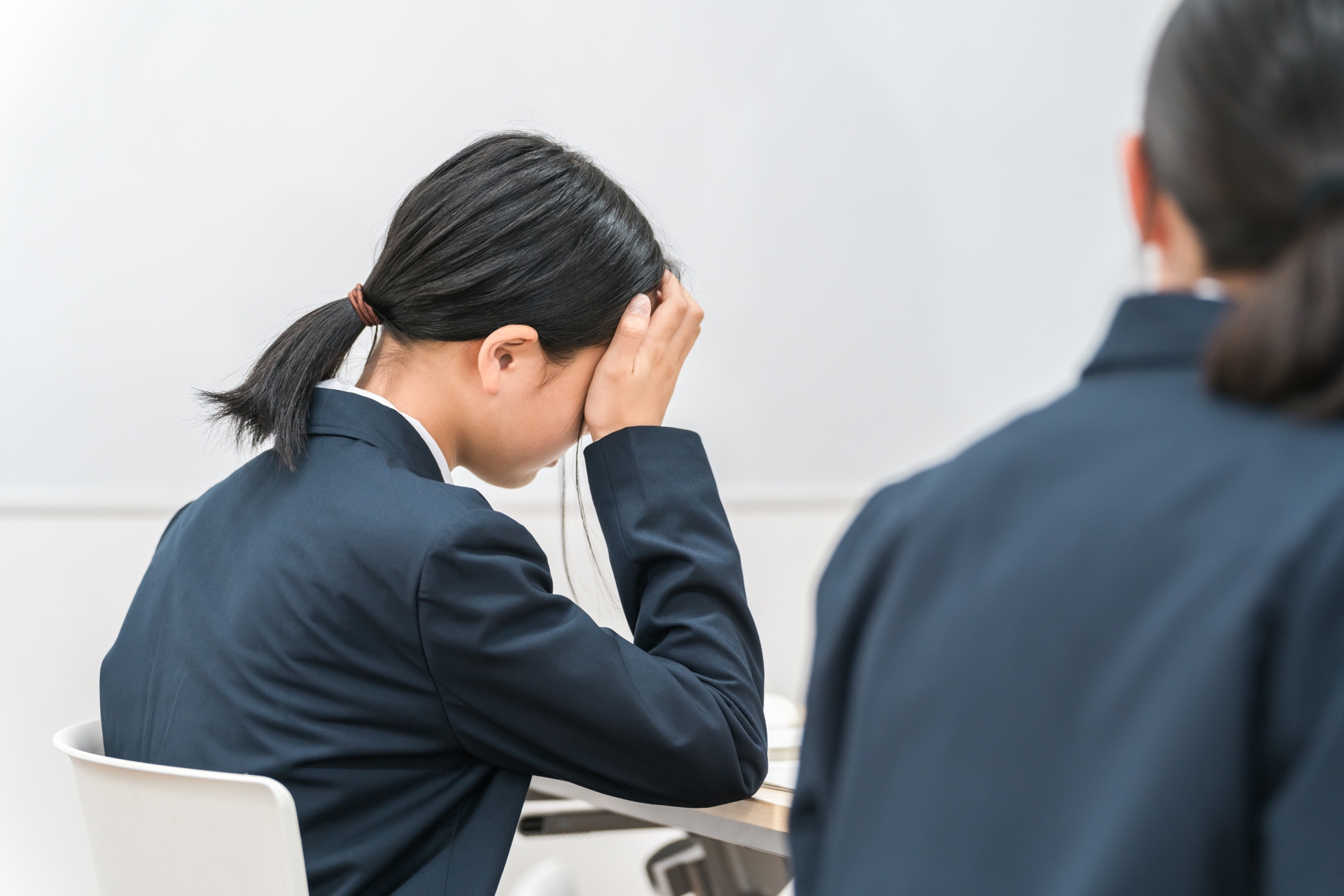 頭痛で頭を押さえるお子さま